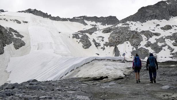 Large white geotextile sheets are seen covering northern Italy's Presena glacier
