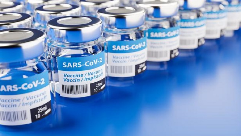 Concept for the availability of enough vaccine against the new corona virus SARS-CoV-2: Rows of glass container of vaccination. The word vaccination in English, Spanish, French and German on the label