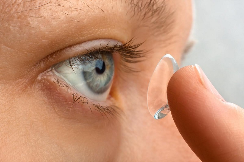 woman putting contact lens in her eye