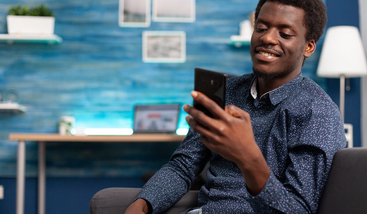 Black man greeting colleagues on video call conference in living room. Working from home african american remote worker in distance communication chat, learning about business project