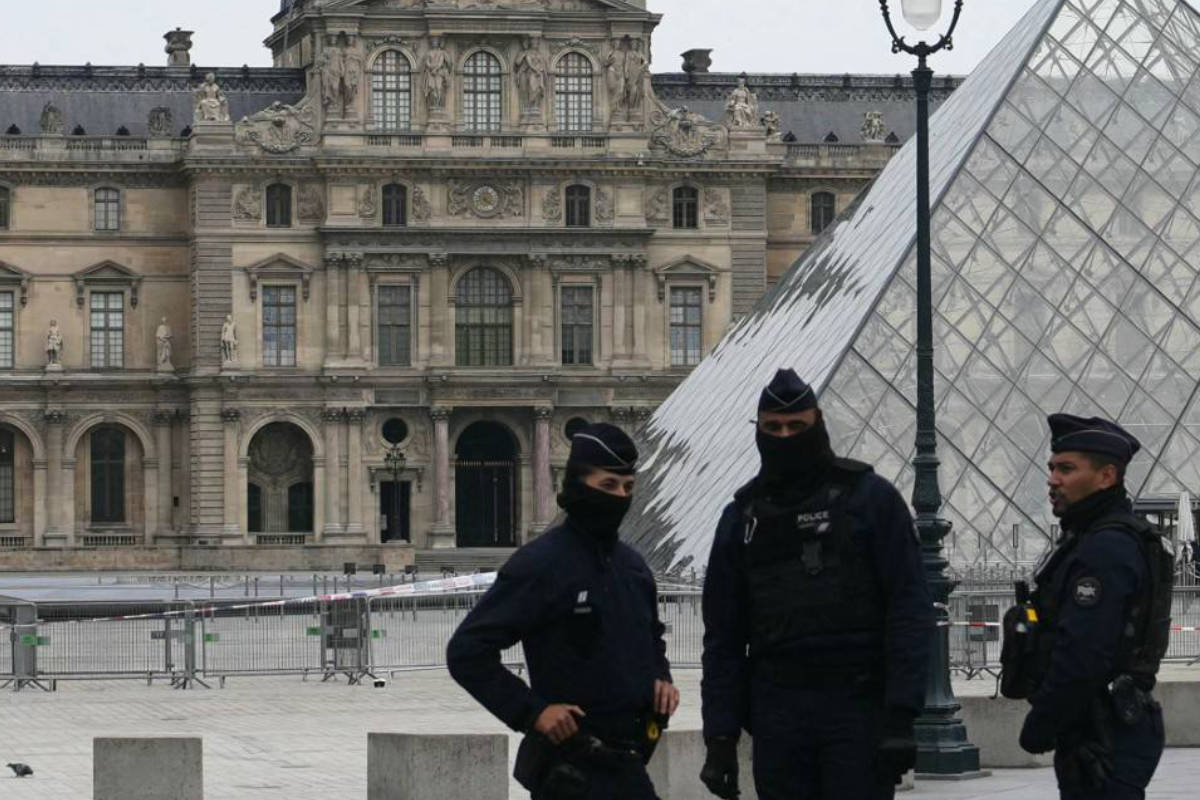 Des policiers français se tiennent devant le musée du Louvre après un cambriolage, à Paris, le 19 octobre 2025.
